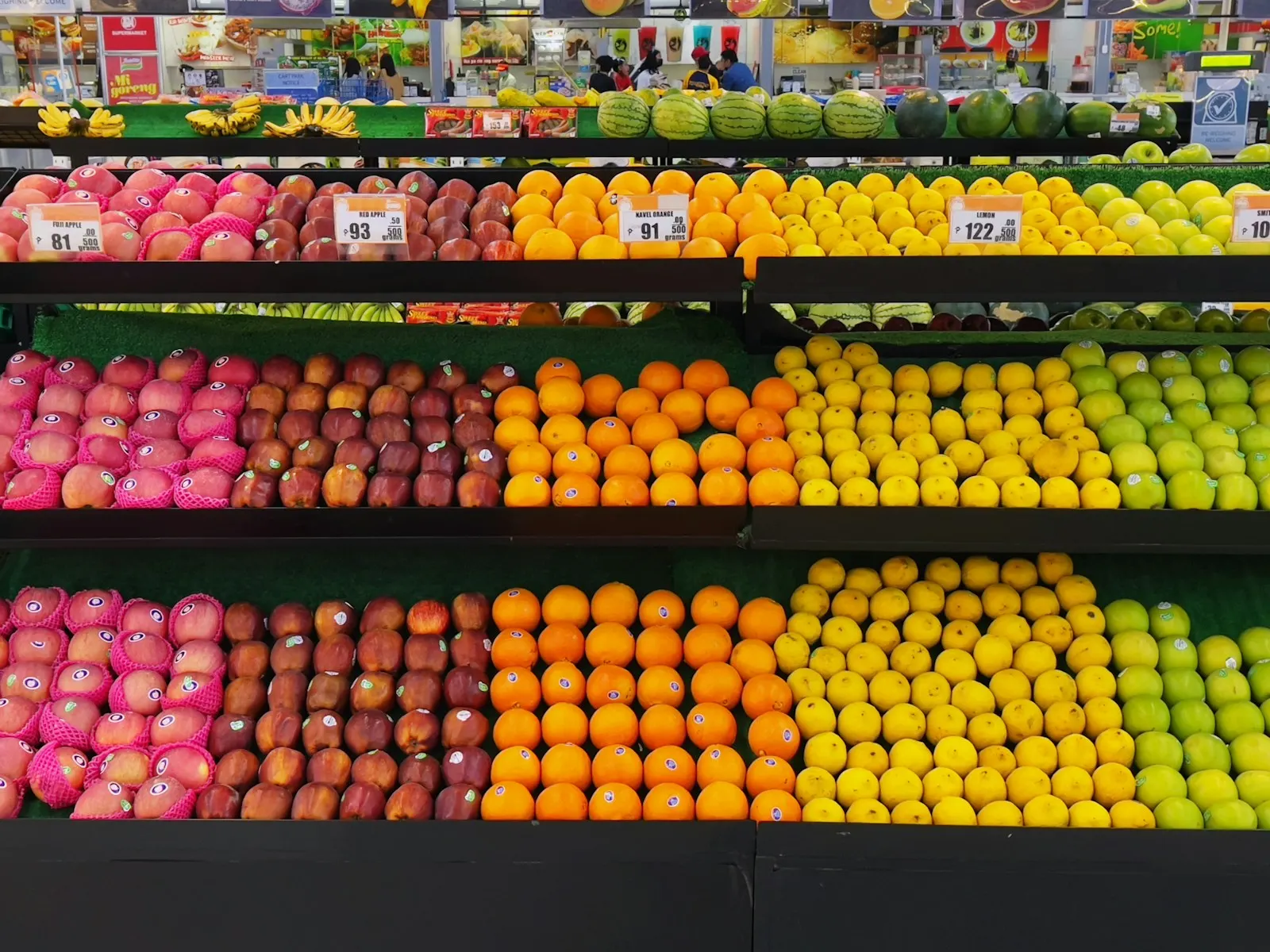 Yellow and red round fruits on black shelf