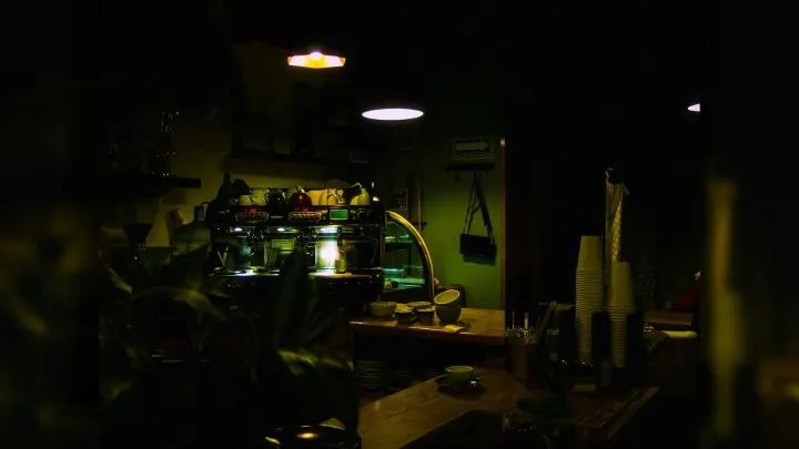 An espresso machine on a wooden counter in a dimly lit coffee shop