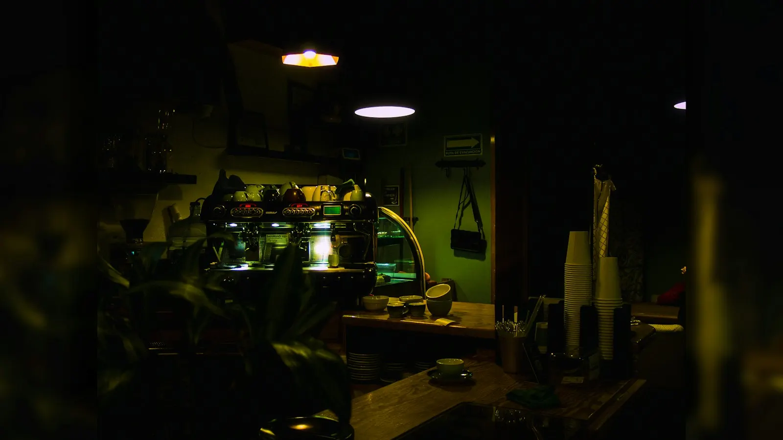 An espresso machine on a wooden counter in a dimly lit coffee shop