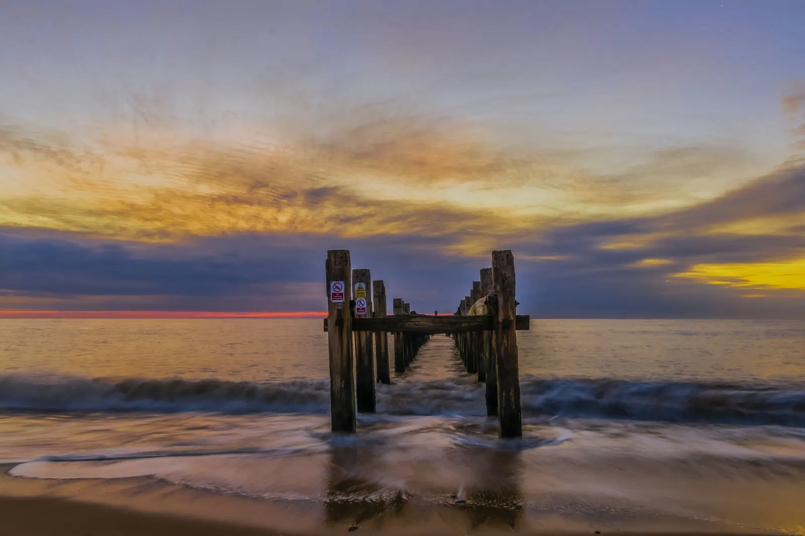 A pier extending into the ocean at sunset