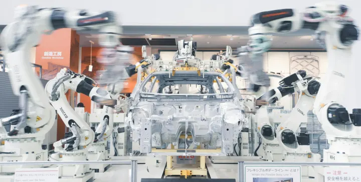 Robotic arms assembling a car chassis on a factory line